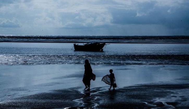 one lady and  a child walking through the seashore