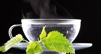 Hot water with a lot of steam in a glass at a black background.