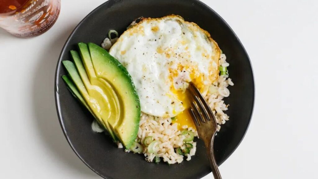 Bowl of rice, egg, and avocado.