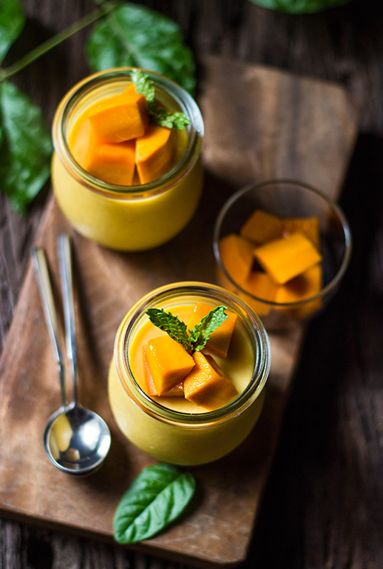 "Delicious and creamy eggless mango pudding topped with fresh mango slices and mint leaves."




