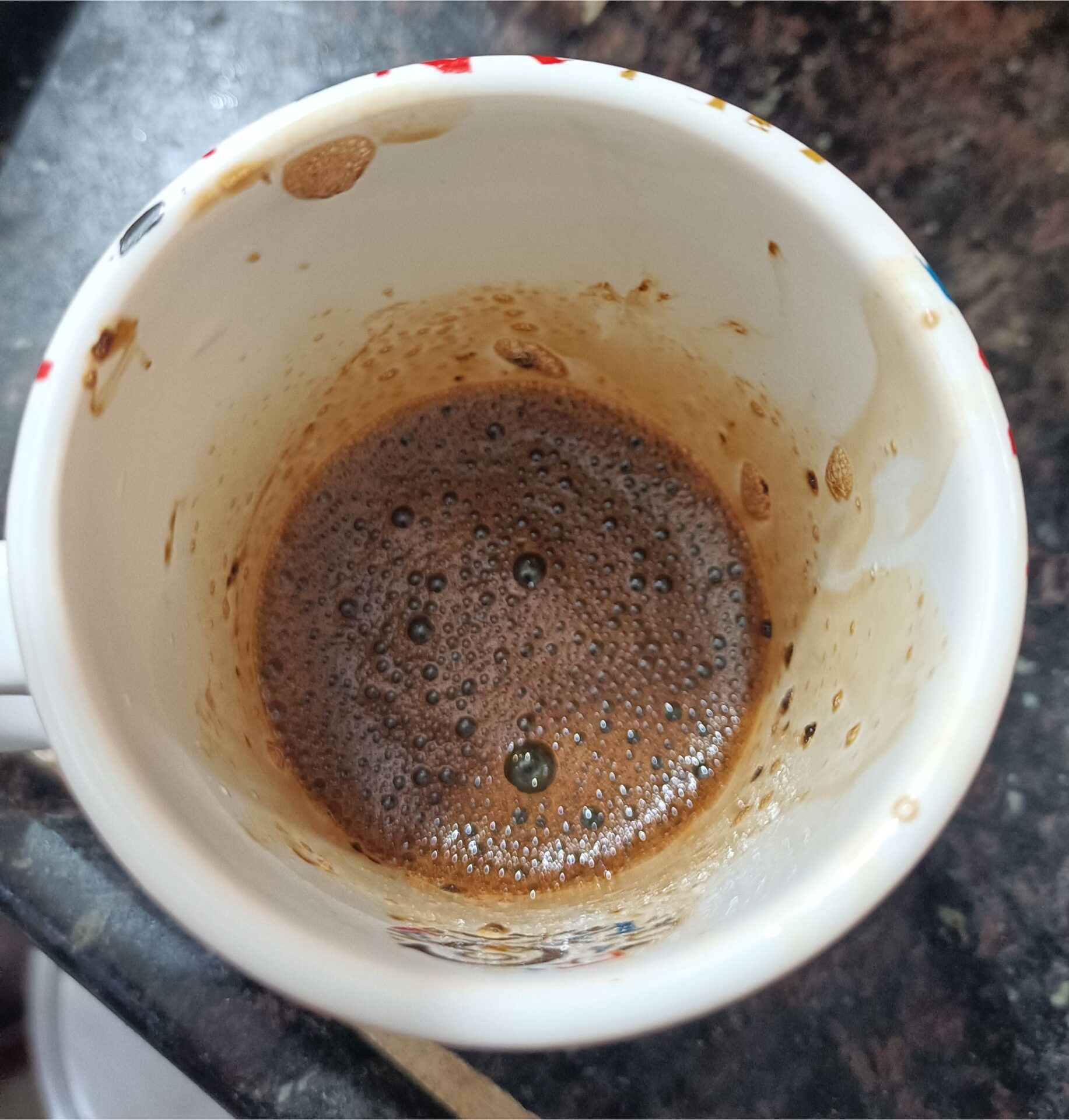 a cup with sugar and coffee powder and hot water