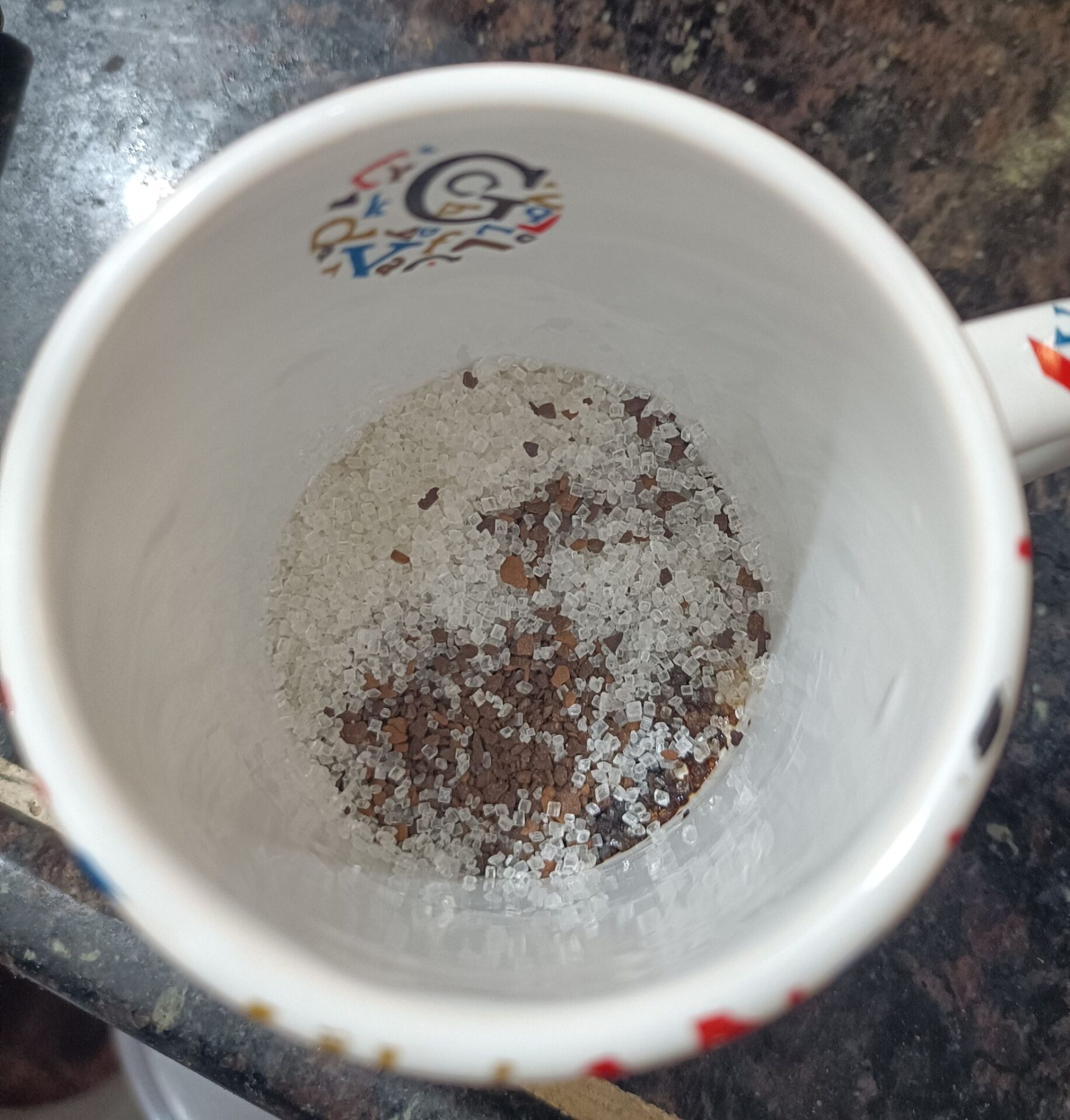 a cup with sugar and coffee powder
